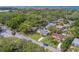 Lovely neighborhood aerial view of homes with mature trees, green lawns, and city and water views in the distance at 1536 Alamo Ln, Dunedin, FL 34698