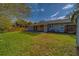 View of a backyard with a spacious grassy area, wooden pergola, and fenced yard at 1536 Alamo Ln, Dunedin, FL 34698