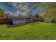 View of a backyard with a spacious grassy area, wooden pergola, and storage shed at 1536 Alamo Ln, Dunedin, FL 34698