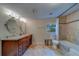 Bathroom with wood vanity, dual sinks, tile flooring, and shower/tub combo at 1536 Alamo Ln, Dunedin, FL 34698