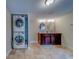 Bathroom features dual sinks, wood vanity, tile flooring, and stackable washer and dryer at 1536 Alamo Ln, Dunedin, FL 34698