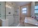 Bathroom featuring a tiled shower with glass door, a tiled floor, a vanity with mirror, and a window at 1536 Alamo Ln, Dunedin, FL 34698