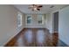 Bright bedroom featuring hardwood floors, a ceiling fan, and double hung windows offering natural light and outside views at 1536 Alamo Ln, Dunedin, FL 34698