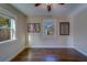 Bedroom featuring hardwood floors, a ceiling fan, and double hung windows allowing natural light and views at 1536 Alamo Ln, Dunedin, FL 34698