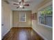 Bedroom featuring hardwood floors, a ceiling fan, and double hung windows allowing natural light and views at 1536 Alamo Ln, Dunedin, FL 34698