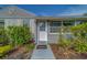 A welcoming front entrance features a white door, sidelight, and neatly trimmed green bushes at 1536 Alamo Ln, Dunedin, FL 34698