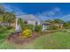 Landscaped front yard of a home featuring vibrant plants, lawn, and a brick walkway at 1536 Alamo Ln, Dunedin, FL 34698