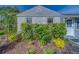 Close-up of house facade with lush green hedges and a well-kept front lawn at 1536 Alamo Ln, Dunedin, FL 34698