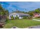 Charming single-story home with a well-manicured front yard and beautiful landscaping at 1536 Alamo Ln, Dunedin, FL 34698
