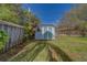 Backyard storage shed in a fenced yard with mature landscaping at 1536 Alamo Ln, Dunedin, FL 34698