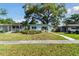 Charming single-story home with a well-manicured front yard and mature trees on a sunny day at 1821 20Th N Ave, St Petersburg, FL 33713