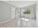Bright and airy living room with white tile flooring, a large window, and a welcoming front door at 1821 20Th N Ave, St Petersburg, FL 33713