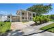 Exterior view of a home with a long driveway, palm trees, and well-manicured lawn at 1842 Nebraska Ne Ave, St Petersburg, FL 33703