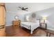 Comfortable main bedroom with hardwood floors, ceiling fan, decorative headboard, and bedside lamps at 1916 38Th W St, Bradenton, FL 34205