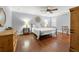 Cozy main bedroom with hardwood floors, ceiling fan, decorative headboard, and ample lighting at 1916 38Th W St, Bradenton, FL 34205