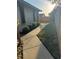 Side yard showcasing a walkway bordered by lush greenery and a wooden fence at 1916 38Th W St, Bradenton, FL 34205