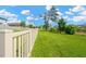 The property is bordered by a white picket fence which separates the grass from a wooded area beyond at 19592 Breynia Dr, Lutz, FL 33558