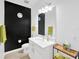 Modern bathroom featuring a black accent wall, white vanity, and modern fixtures at 19592 Breynia Dr, Lutz, FL 33558