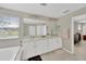 Primary bathroom with double sinks, large vanity, soaking tub, and natural light at 19592 Breynia Dr, Lutz, FL 33558