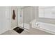 Bathroom featuring marble walk-in shower and a soaking tub under a bright window at 19592 Breynia Dr, Lutz, FL 33558