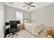 Cozy bedroom with a ceiling fan, natural light, a neutral color scheme, and a working desk at 19592 Breynia Dr, Lutz, FL 33558