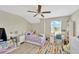 Bedroom with a vaulted ceiling and colorful rug, creating a cozy and stylish space at 19592 Breynia Dr, Lutz, FL 33558