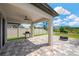 A patio with a ceiling fan, brick paved surface with an outdoor kitchen overlooking the green backyard at 19592 Breynia Dr, Lutz, FL 33558