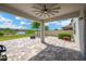 A covered patio with a ceiling fan, and an outdoor kitchen set upon a brick paved surface overlooking the water at 19592 Breynia Dr, Lutz, FL 33558