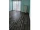 Bright bedroom with wood-look floors, light blue walls, and a sliding door to the outdoors at 1960 Lakewood Club Dr S # 2-F, St Petersburg, FL 33712