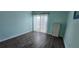 Cozy bedroom with wood-look flooring, light blue walls, and a sliding glass door to the porch at 1960 Lakewood Club Dr S # 2-F, St Petersburg, FL 33712