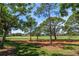 Scenic view of the lush green golf course, featuring mature trees and a meticulously maintained lawn at 21 Pelican Pl, Belleair, FL 33756