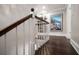 Hallway with dark hardwood floors, a white banister, and an art piece hanging on the wall at 21 Pelican Pl, Belleair, FL 33756