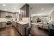 Modern kitchen with gray cabinetry, stainless steel appliances, and an open layout to the living room at 21 Pelican Pl, Belleair, FL 33756