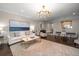 Inviting living room featuring a large painting, modern chandelier, and comfortable seating arrangement at 21 Pelican Pl, Belleair, FL 33756
