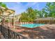 Inviting community pool area with brick-paved surround and shaded pergola at 21 Pelican Pl, Belleair, FL 33756