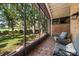 Relaxing screened porch with brick flooring and views of the green golf course beyond at 21 Pelican Pl, Belleair, FL 33756