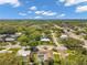 A bird's eye view of a neighborhood with mature trees, well-maintained lawns, and a home with a private pool at 2216 El De Oro Dr, Clearwater, FL 33764