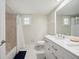 Bright bathroom features tiled shower, white cabinets, and framed mirror at 2216 El De Oro Dr, Clearwater, FL 33764