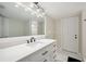 Bright bathroom featuring a single sink vanity, large mirror, and white door at 2216 El De Oro Dr, Clearwater, FL 33764