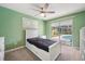 Cozy bedroom with a ceiling fan, a sliding door, and views of the outdoor pool area at 2216 El De Oro Dr, Clearwater, FL 33764
