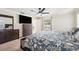Spacious main bedroom featuring a ceiling fan, tv, and ample dresser space overlooking the pool at 2216 El De Oro Dr, Clearwater, FL 33764