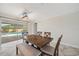 Well-lit dining room featuring wooden table with a view to a screened pool area and patio at 2216 El De Oro Dr, Clearwater, FL 33764