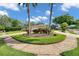 Well-manicured front yard with circular driveway, lush landscaping and mature trees at 2216 El De Oro Dr, Clearwater, FL 33764