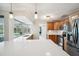 Bright kitchen boasts stainless appliances, natural wood cabinetry, and elegant countertops overlooking the backyard pool at 2216 El De Oro Dr, Clearwater, FL 33764
