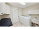 Functional laundry room with appliances, cabinets, countertop, and tiled flooring at 2216 El De Oro Dr, Clearwater, FL 33764