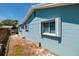A house with blue siding and white trim, showcasing simple window design and a clean, modern aesthetic at 2972 E Vina Del Mar Blvd, St Pete Beach, FL 33706