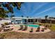 Backyard with pool surrounded by brick patio and tropical landscaping at 2972 E Vina Del Mar Blvd, St Pete Beach, FL 33706