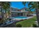 Backyard of home with a pool, patio, garden, and manicured lawn with palm trees at 3385 Clarine E Way, Dunedin, FL 34698