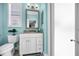 Bathroom with a vanity, granite countertop, and a shower featuring light-blue walls at 3385 Clarine E Way, Dunedin, FL 34698
