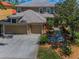 Exterior view of two story home featuring a two car garage, landscaped yard, and neutral color palette at 3385 Clarine E Way, Dunedin, FL 34698